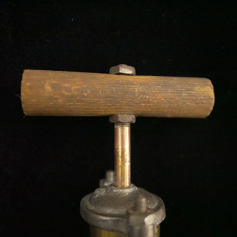 Solid brass antique bilge pump with wooden handle.