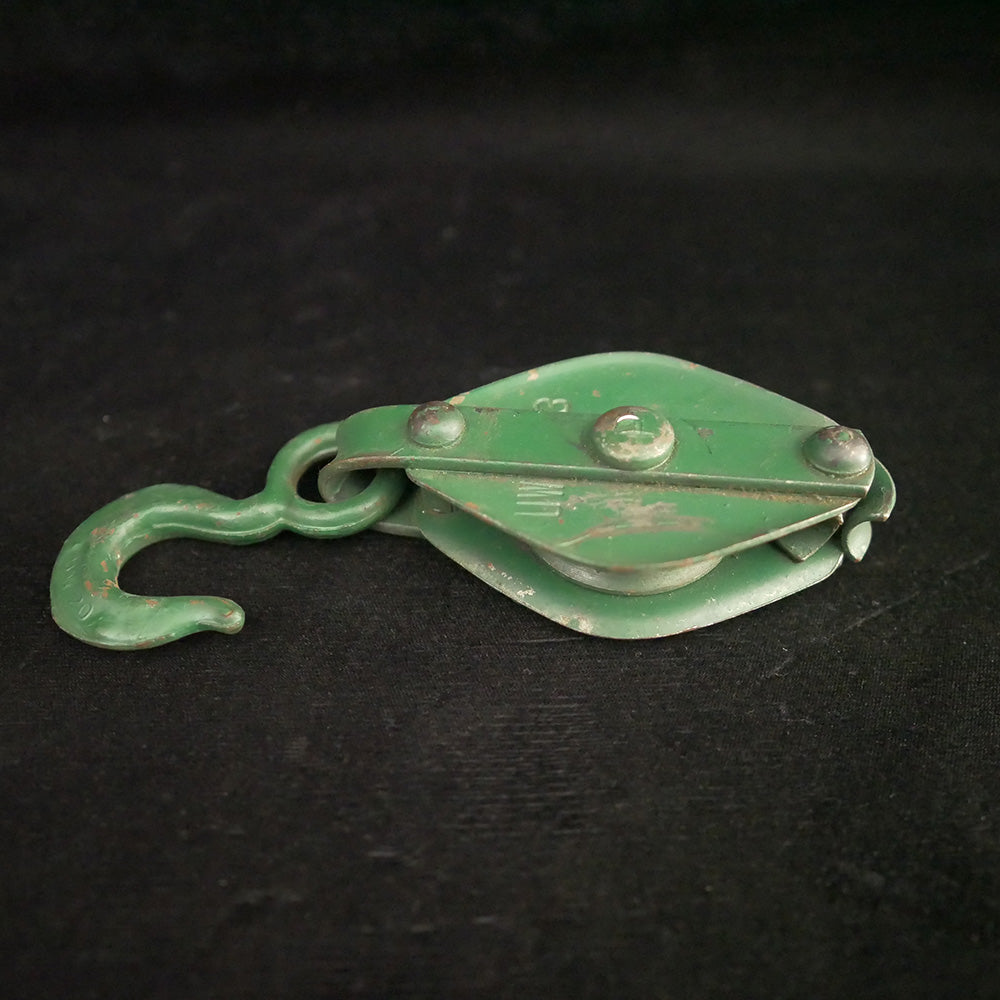 Antique green 7-inch single sheave metal block pulley.